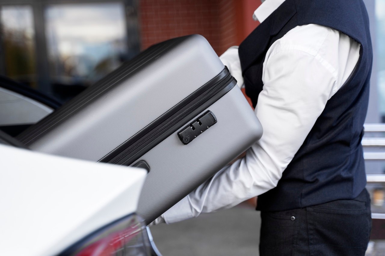 side view valet holding baggage